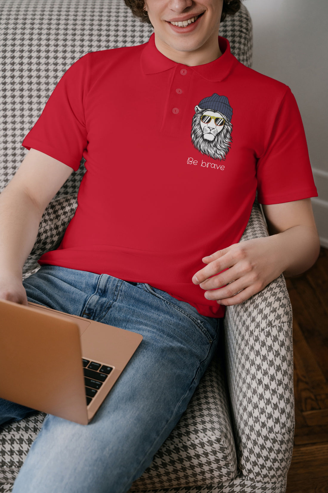 Close-up of The Edi Archive’s ‘Be Brave’ red polo T-shirt showing the lycra ribbed neck and lion cap graphic on the chest.