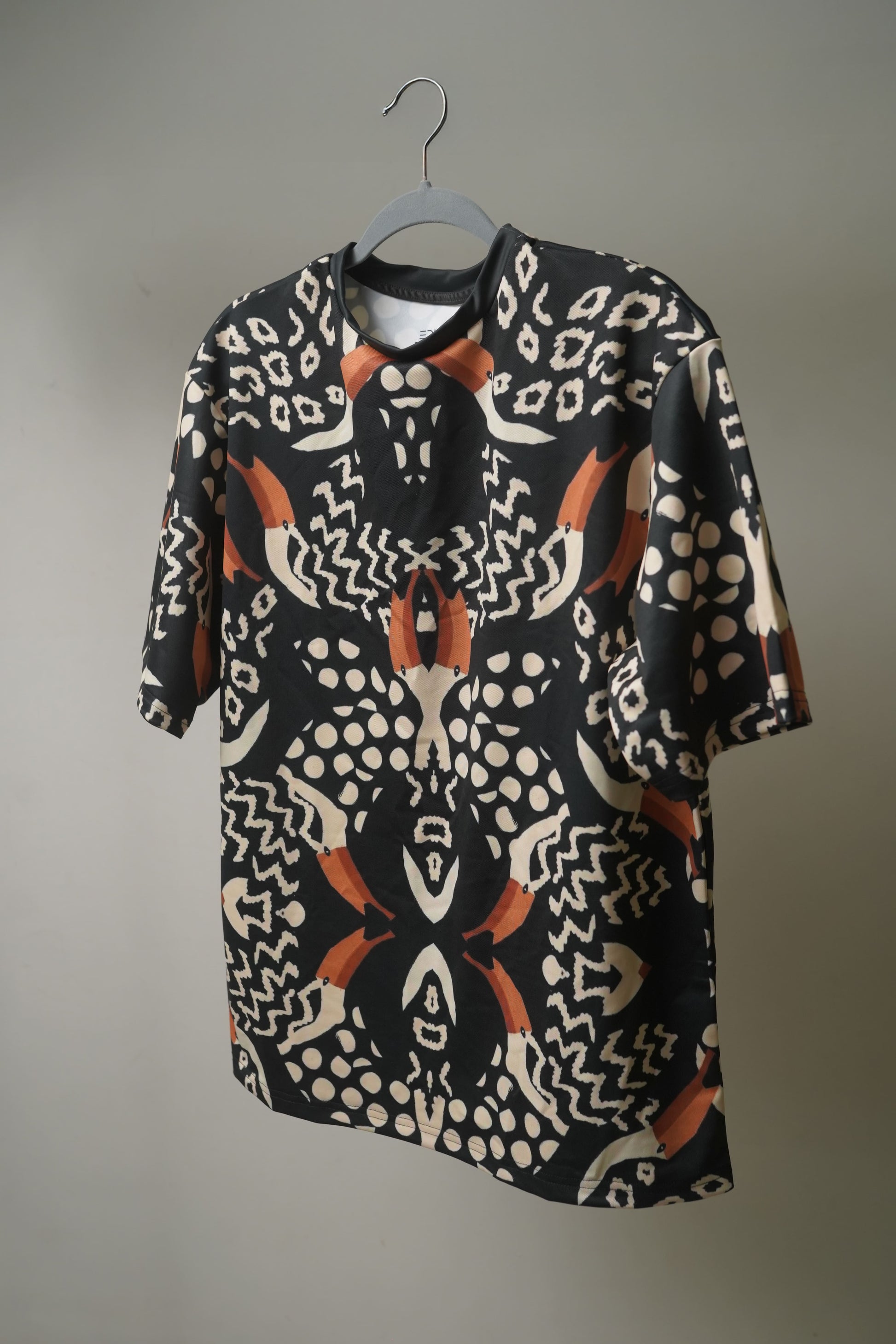 Side profile of  Pelican Breeze Unisex Oversized T-Shirt from The Edi Archive, showing drop-shoulder fit and airy fabric flow