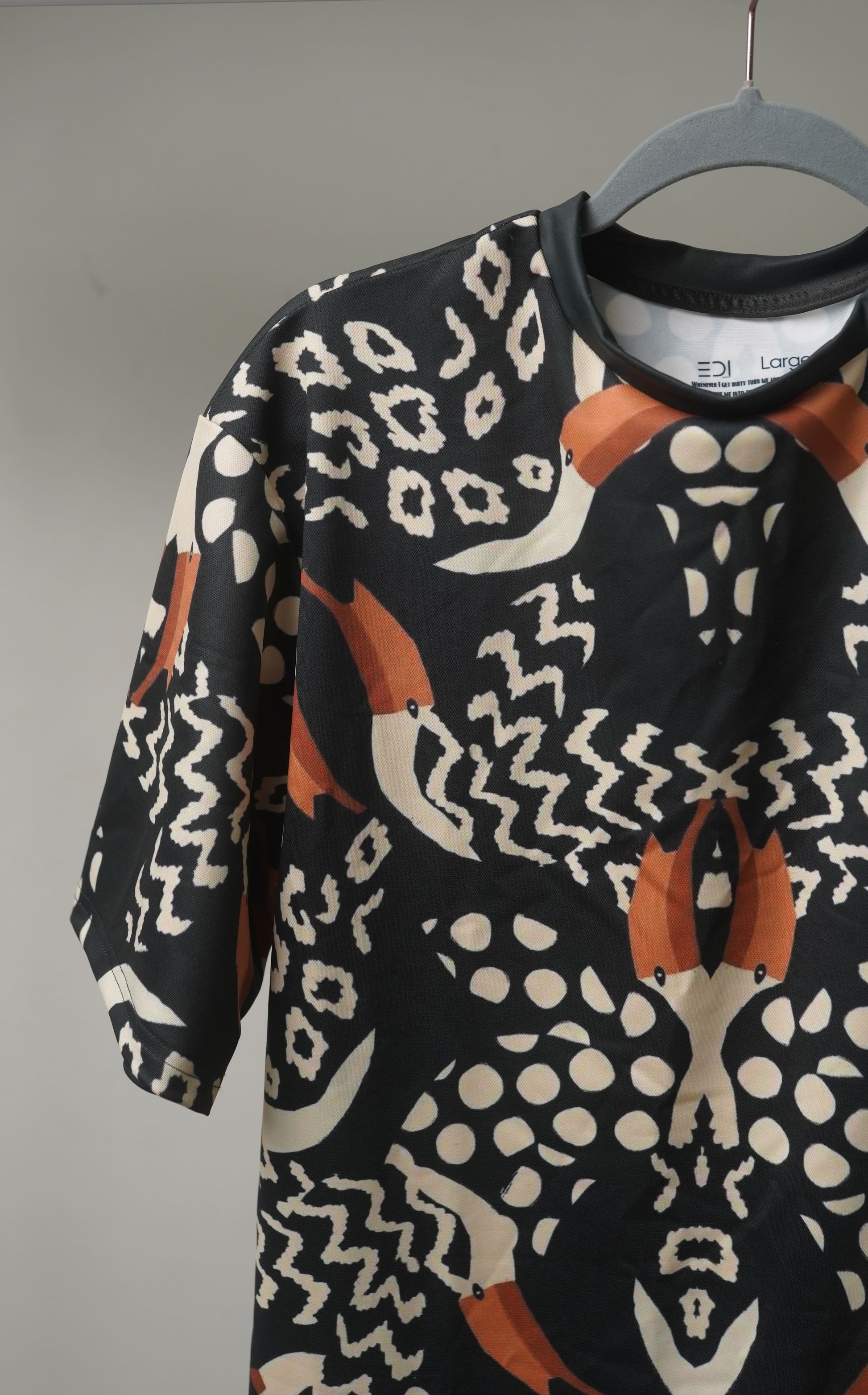 Close-up of  Pelican Breeze Unisex Oversized T-Shirt from The Edi Archive, featuring sleeve with detailed pelican and wave print