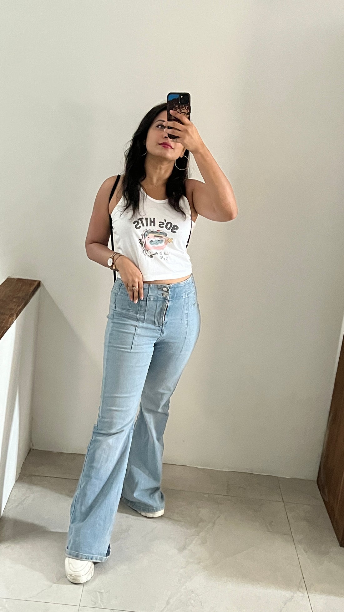 A woman wearing the 90s Music white crop tank top from The Edi Archive’s Ctrl+Me Collection – nostalgic cotton vibe with cassette-themed print.