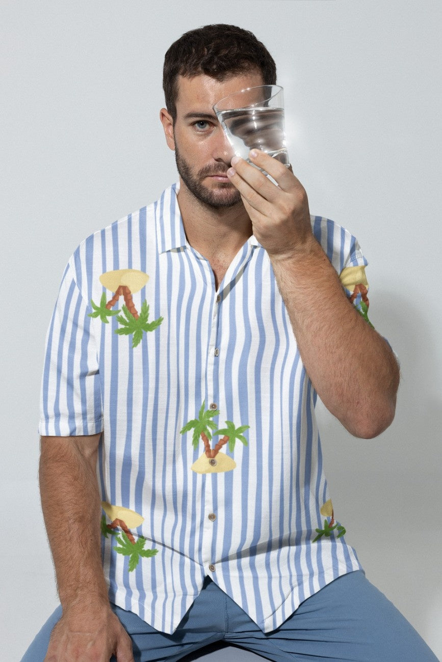 Man wearing Nature's Paradise Men's Hawaiian Shirt from The Edi Archive, holding a glass.