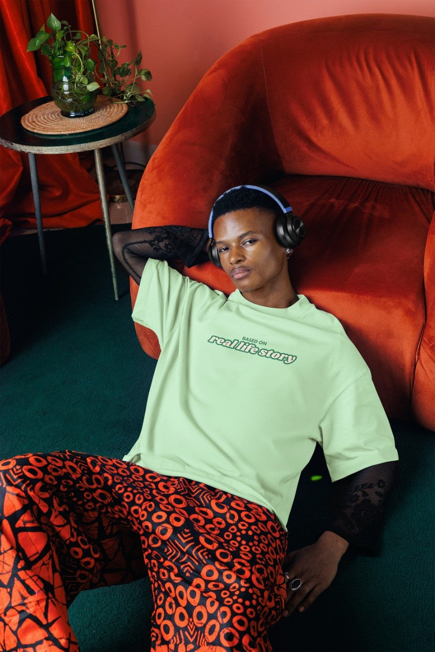 A man wearing 'Based On Real Life Story Unisex Oversized T-Shirt' from The Edi Archive - Ctrl+Me Collection