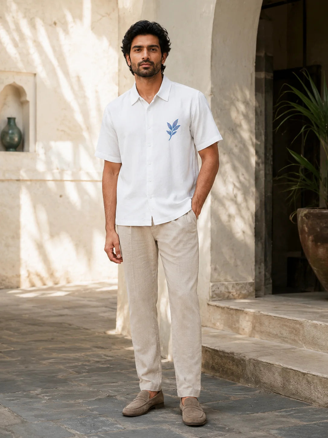Full length front view of a man in a white botanical print shirt with a classic spread collar and beige trousers, Ink Leaf Hawaiian Shirt, Tropical Drop, The Edi Archive