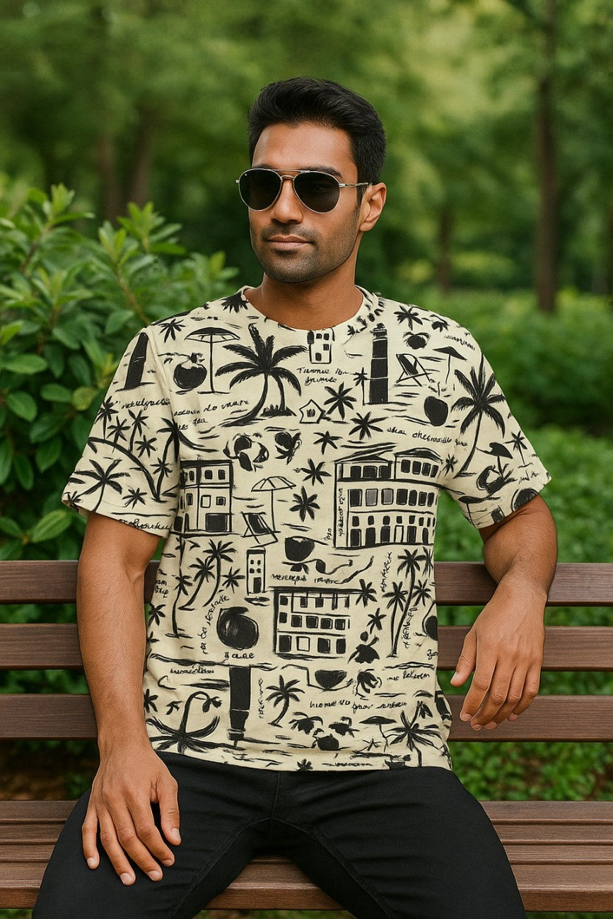 Man wearing a patterned oversized T-Shirt, Live Wild from The Edi Archive, sitting on a bench with a green, leafy background
