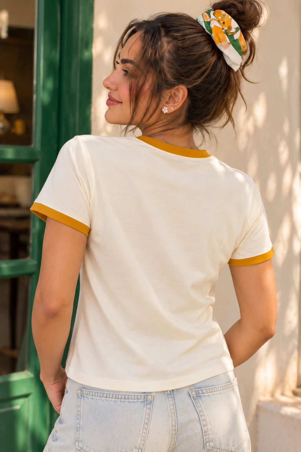Back view of a cream ringer T-shirt with mustard neck and sleeve piping, shown with no graphic or print on the back.