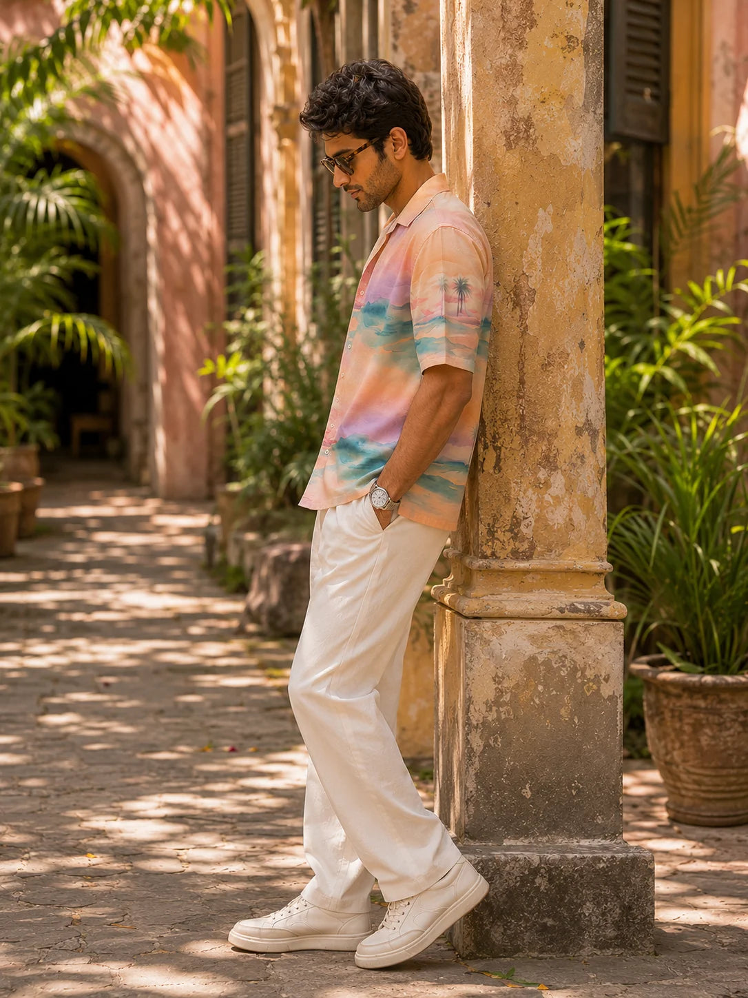 Side profile of a man in a relaxed fit cotton linen tropical print shirt leaning against a stone column, Mirage Hawaiian Shirt, Tropical Drop, The Edi Archive