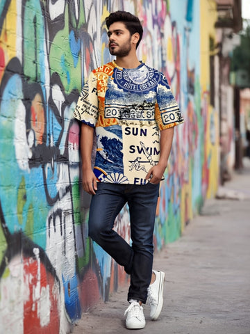 Man wearing a colorful patterned oversized t-shirt, Sun Swim Sea from The Edi Archive, standing in front of a graffiti wall.