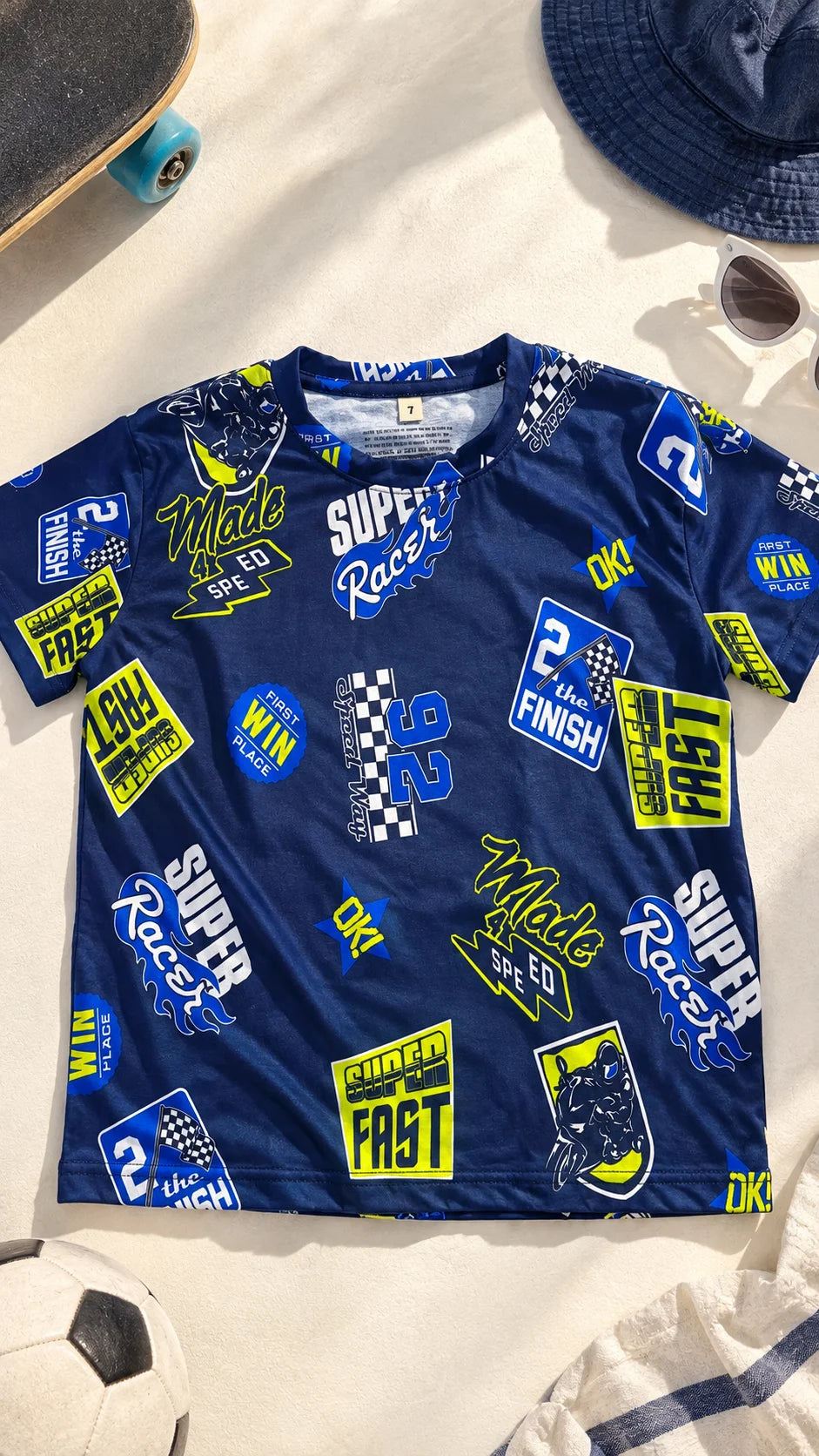 Super Racer Kids AOP T-Shirt by The Edi Archive shown flat lay with all-over blue racing graphics and sporty illustrations