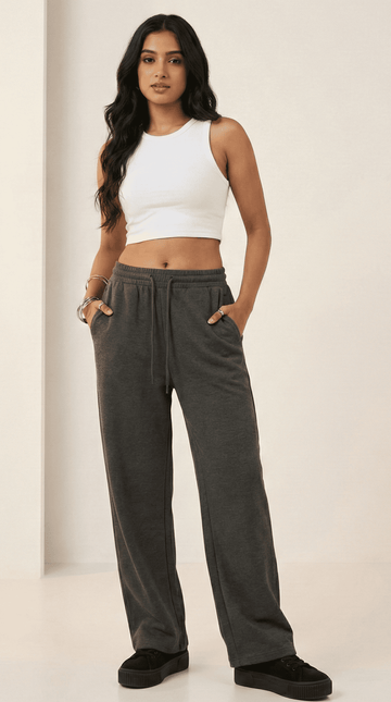 Woman wearing a white tank top and charcoal comfy chaos unisex sweatpants from The Edi Archive, front view.