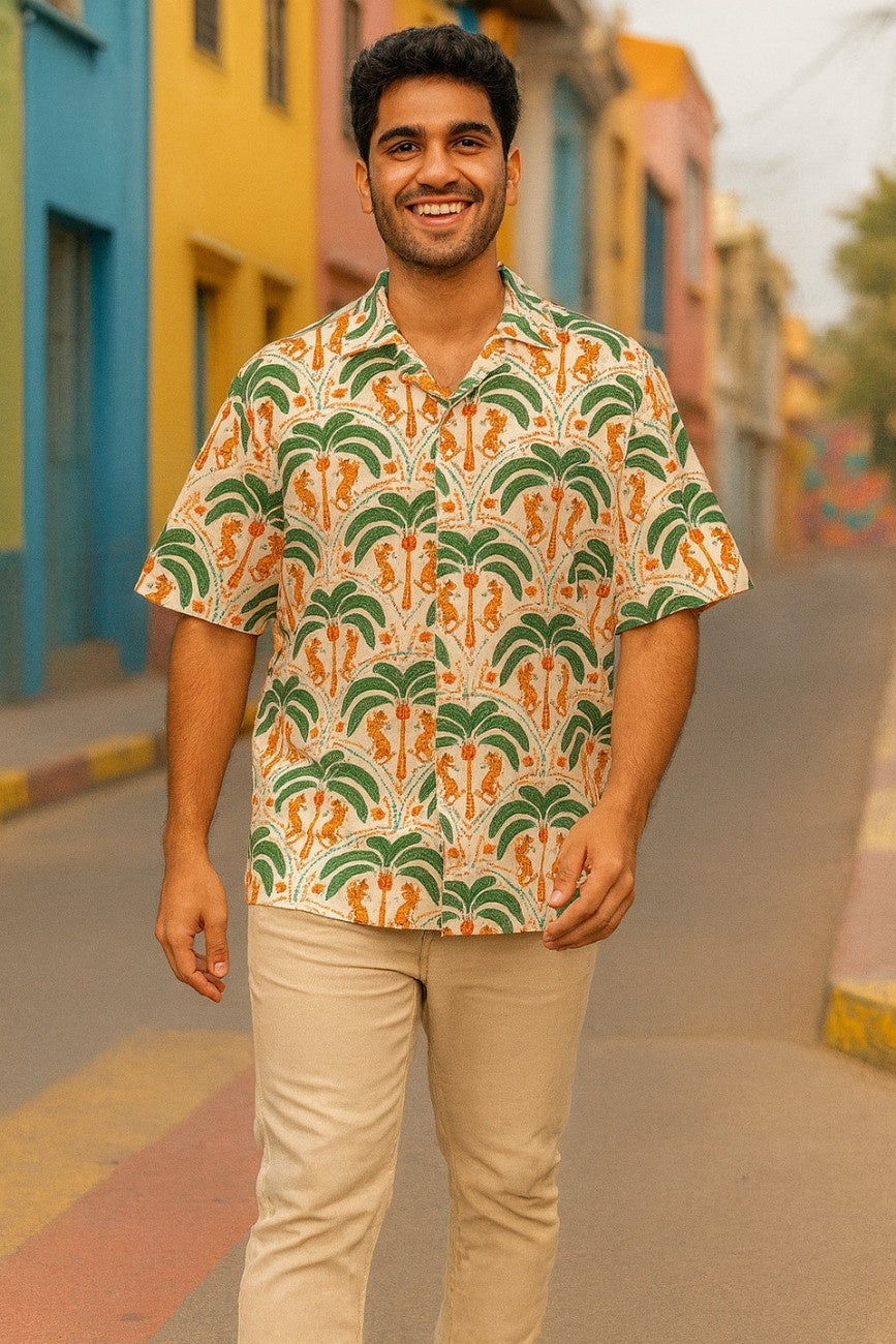 Man wearing a Tiger Palms Men's Hawaiian Shirt from Tropical Drops from The Edi Archive, standing on a colorful street.