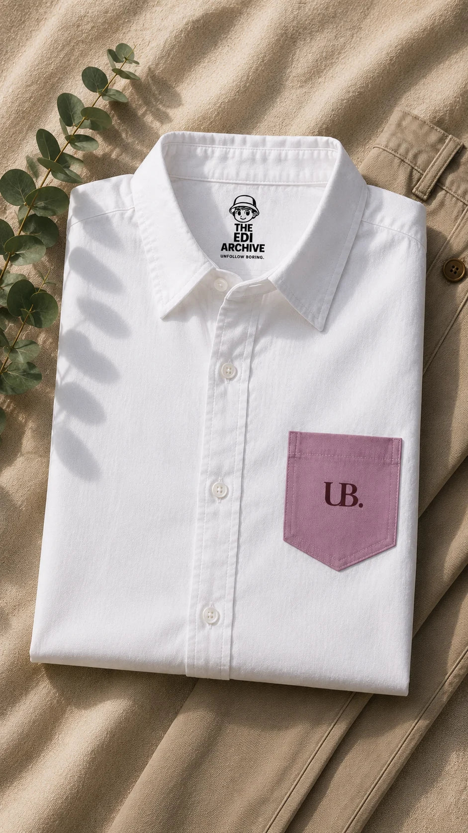 Fine Print unisex oversized white cotton shirt folded flatlay with The Edi Archive neck label and blush UB. printed pocket, Ctrl+Me collection by The Edi Archive