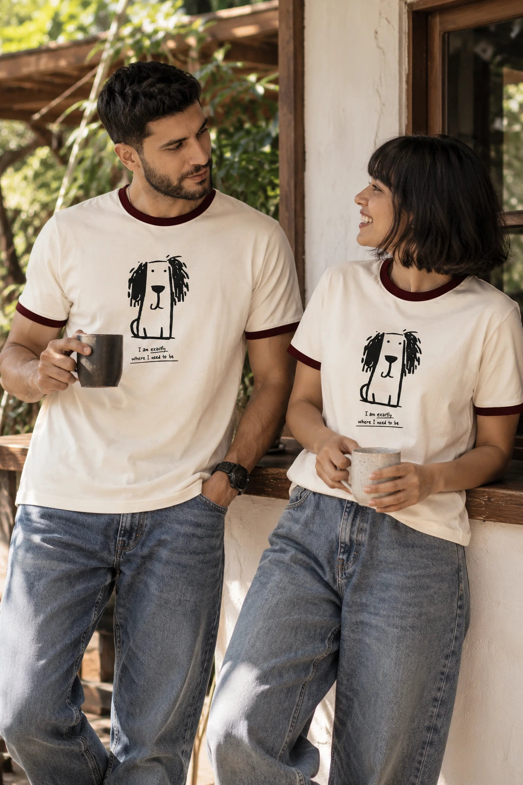Man and woman wearing matching off-white dog graphic ringer T-shirts with maroon contrast trim, front view of The Edi Archive Ctrl+Me Collection design.